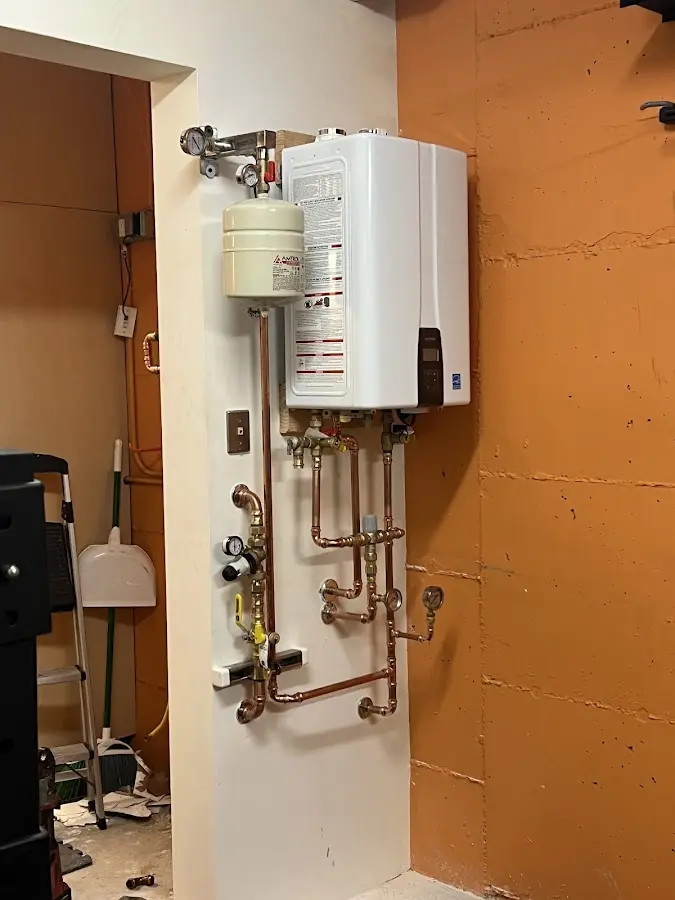 Plumbing technician inspecting water heater connections in Hawaiian Beaches